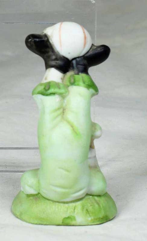 Small clown doing a handstand with a ball