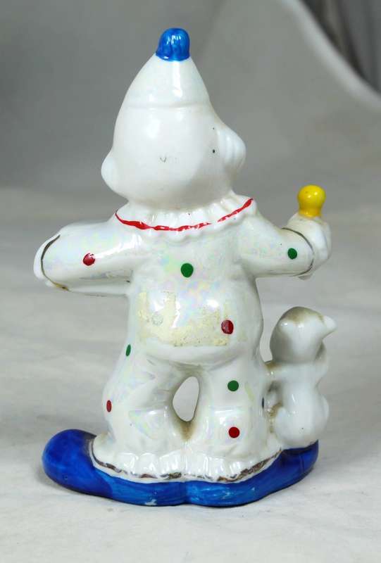 Small clown holding a dog and a drum