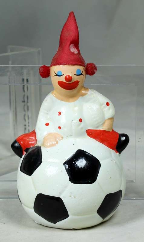 Small clown in a polka dot suit and hat  on a large ball