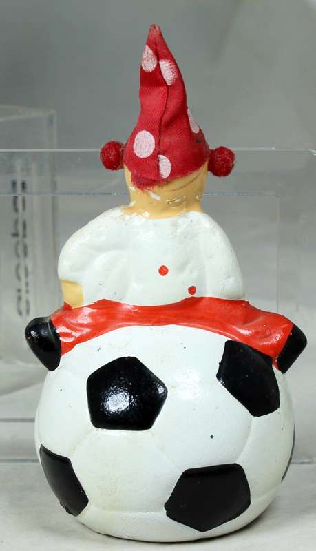 Small clown in a polka dot suit and hat  on a large ball
