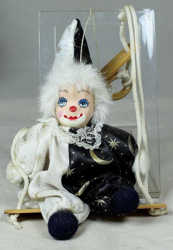 Small clown in a wizard jump suit on a swing