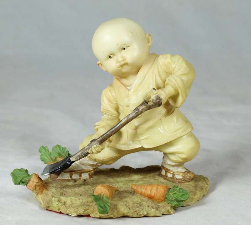 A baby Buddha - Monk with a spade gardening