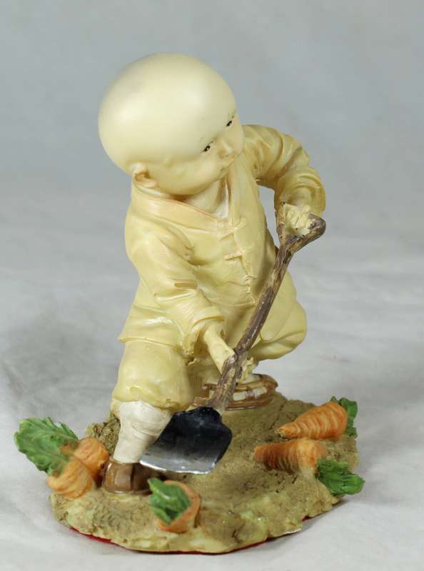 A baby Buddha - Monk with a spade gardening