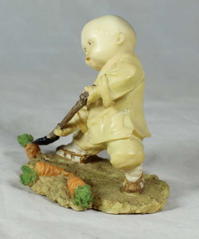 A baby Buddha - Monk with a spade gardening