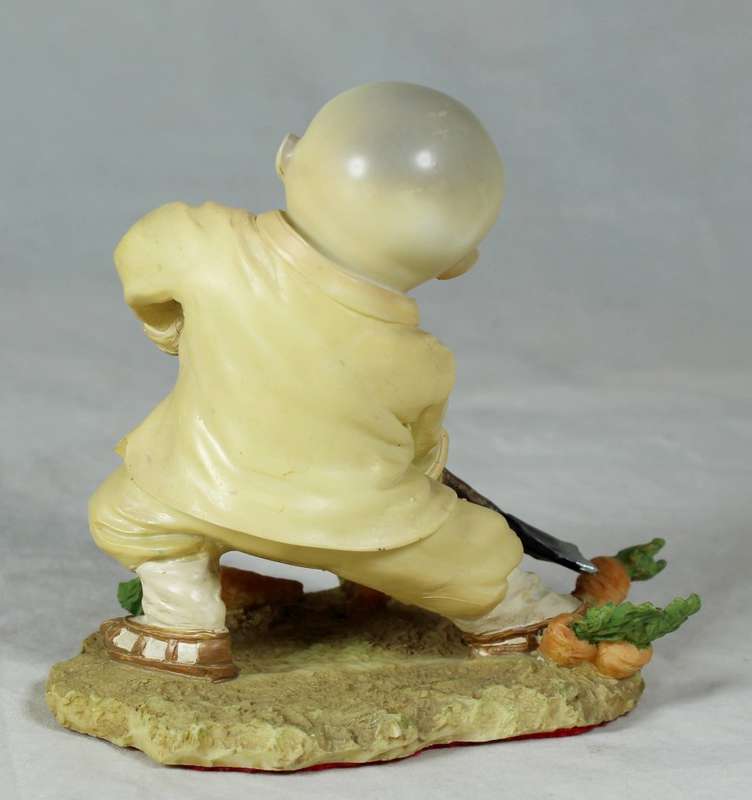 A baby Buddha - Monk with a spade gardening