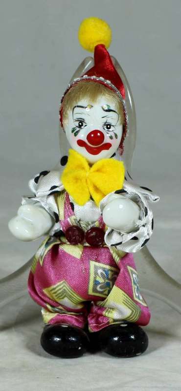 PORCERLAIN CLOWN DRESSED IN A JUMP SUIT WITH A RED HAT