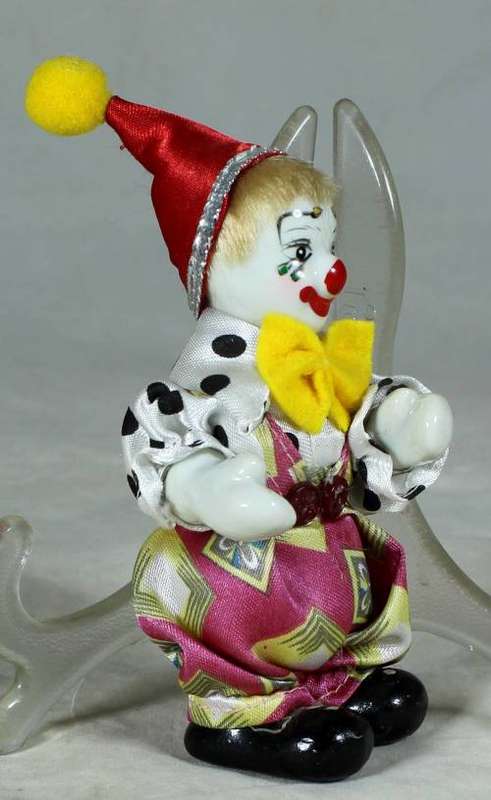 PORCERLAIN CLOWN DRESSED IN A JUMP SUIT WITH A RED HAT