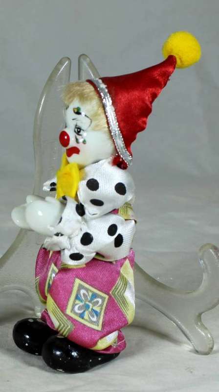 PORCERLAIN CLOWN DRESSED IN A JUMP SUIT WITH A RED HAT