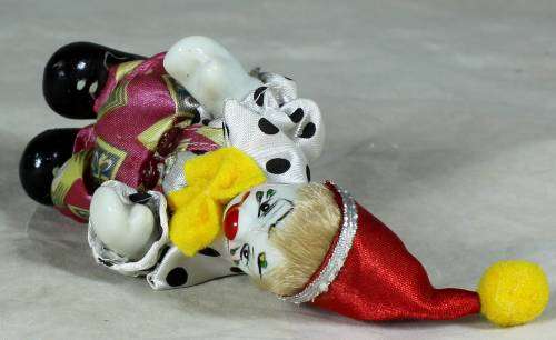 PORCERLAIN CLOWN DRESSED IN A JUMP SUIT WITH A RED HAT