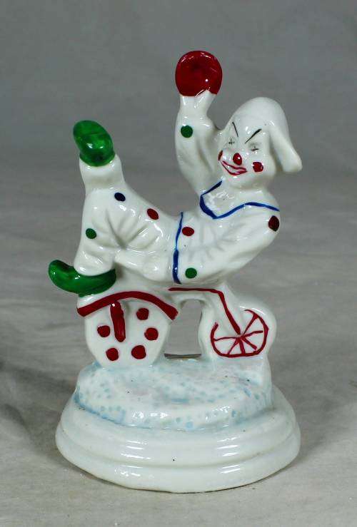 Porcelain clown sitting on a tricycle