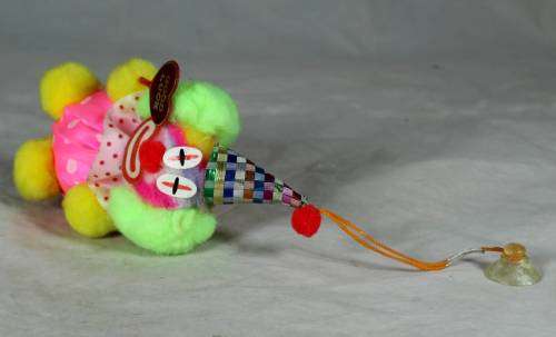 Fuzzy clown dressed in pink holding a good luck sign