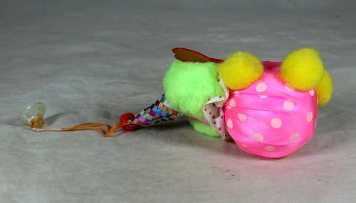 Fuzzy clown dressed in pink holding a good luck sign