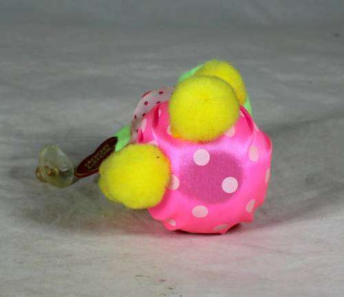 Fuzzy clown dressed in pink holding a good luck sign