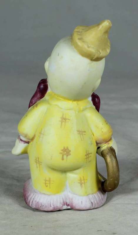 Ceramic clown in a brown bowtie carrying a ring