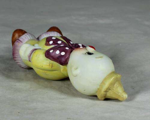 Ceramic clown in a brown bowtie carrying a ring