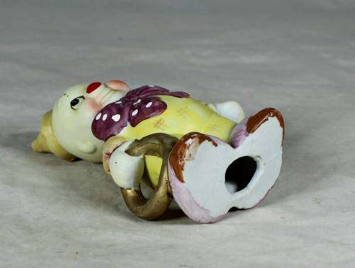 Ceramic clown in a brown bowtie carrying a ring