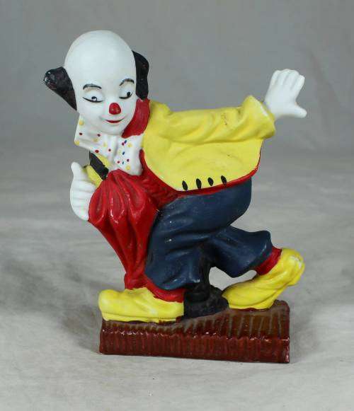 Ceramic clown on a stand striking a pose