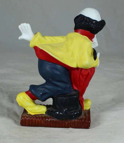 Ceramic clown on a stand striking a pose