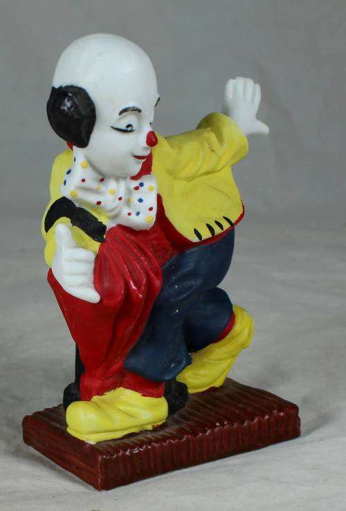 Ceramic clown on a stand striking a pose