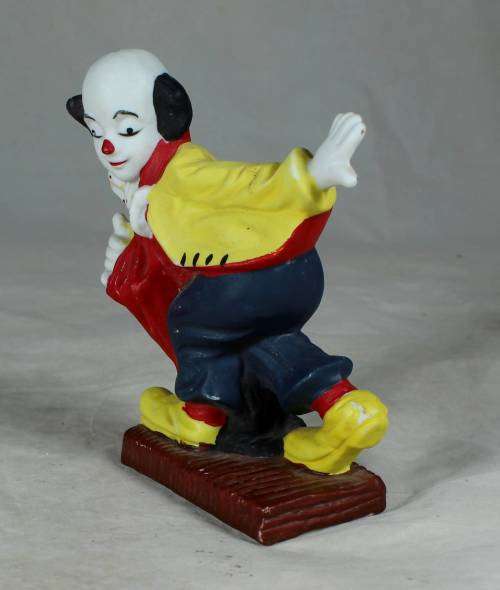 Ceramic clown on a stand striking a pose