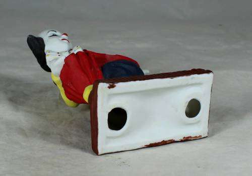 Ceramic clown on a stand striking a pose
