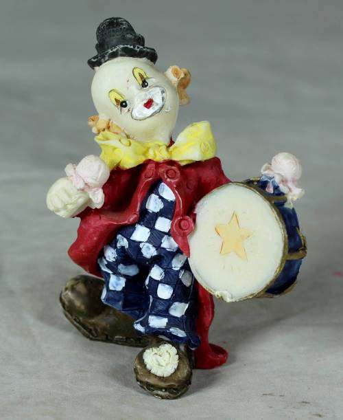 Molded clown playing a drum