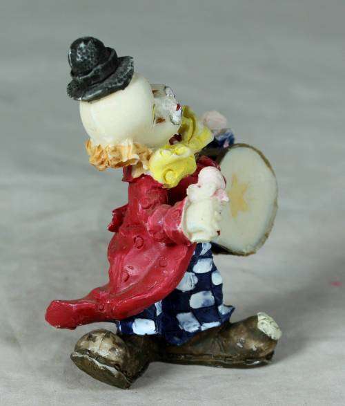 Molded clown playing a drum