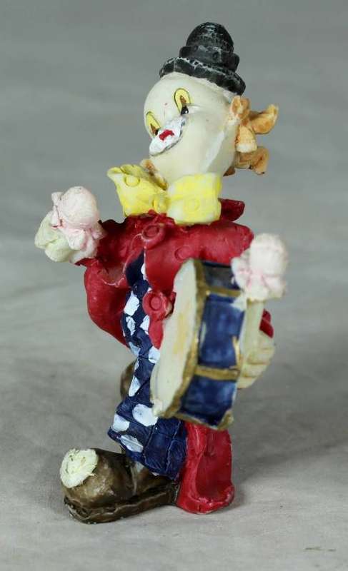 Molded clown playing a drum