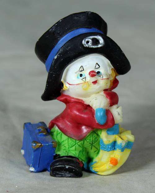 MOLDED CLOWN IN A  BLACK HAT & UMBRELLA WITH A SUITCASE
