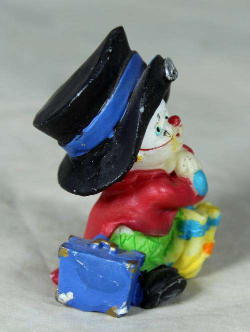 MOLDED CLOWN IN A  BLACK HAT & UMBRELLA WITH A SUITCASE