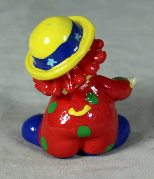 Molded clown in a yellow hat with red hair