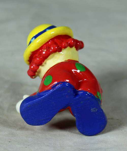 Molded clown in a yellow hat with red hair