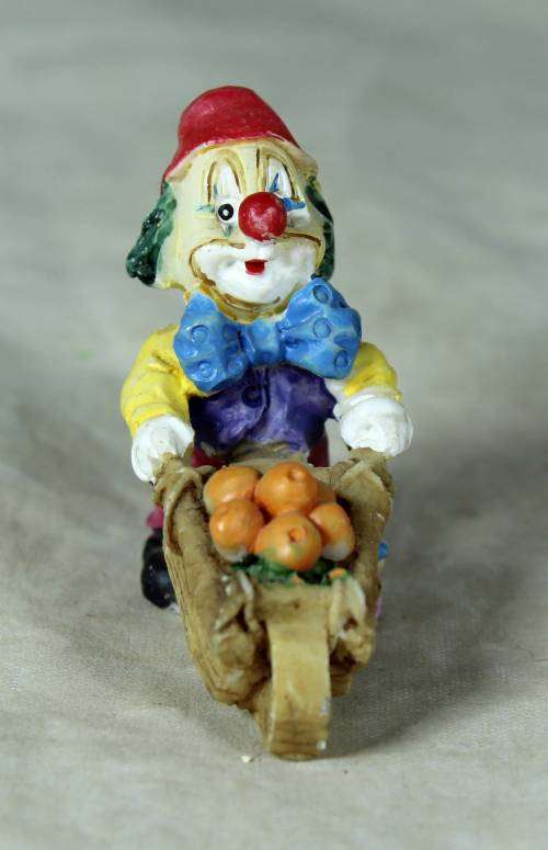 Molded clown pushing a fruit basket