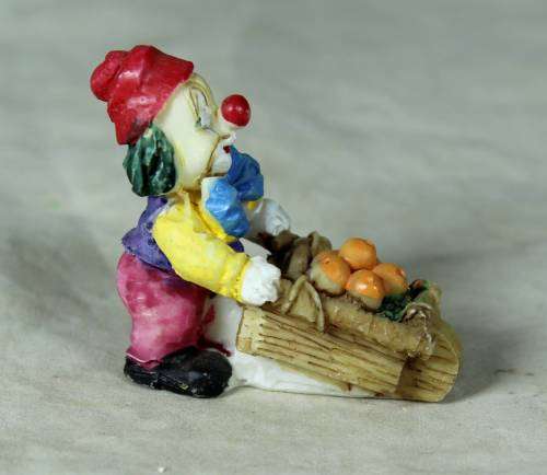 Molded clown pushing a fruit basket