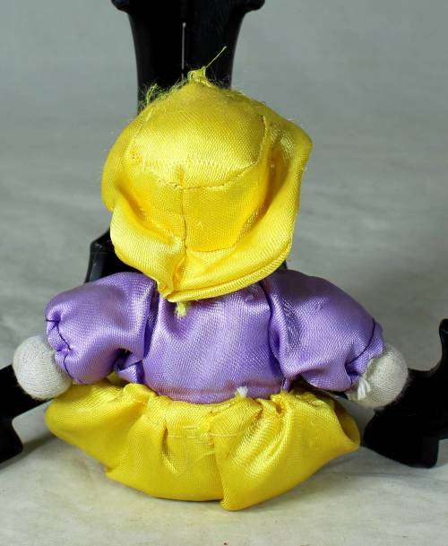 porcelain and cloth clown in a yellow hat and pants