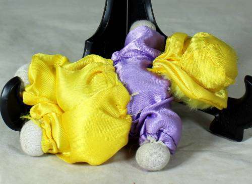 porcelain and cloth clown in a yellow hat and pants