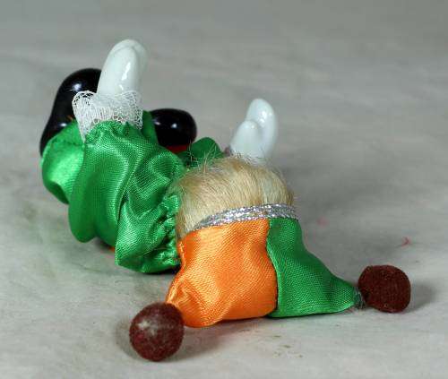 porcelain and cloth clown in a green and orange suit