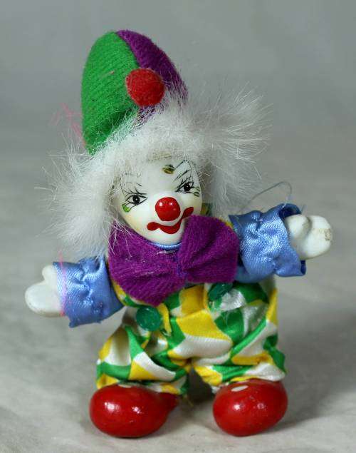 porcelain and cloth clown with a purple bowtie
