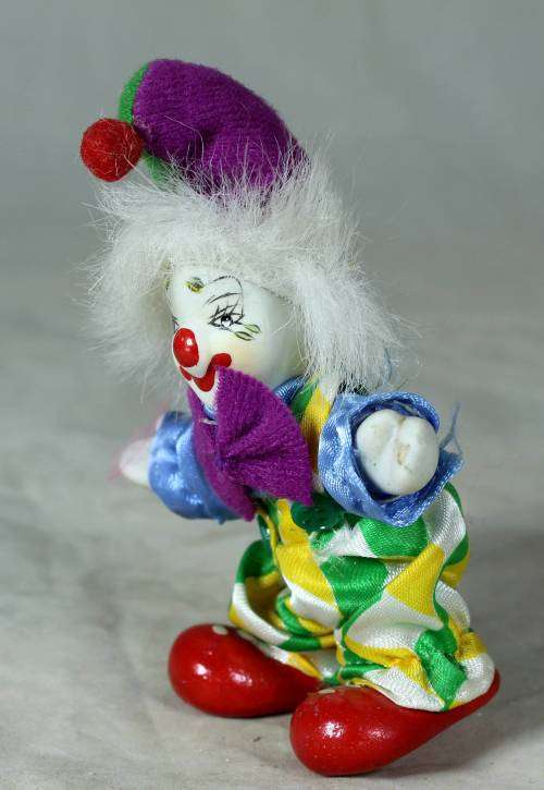 porcelain and cloth clown with a purple bowtie