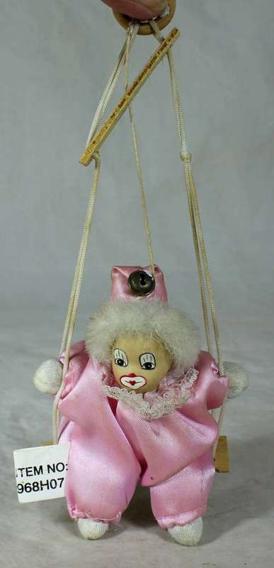 PORCERLAIN AND CLOTH CLOWN DRESSED IN PINK ON A ROPE
