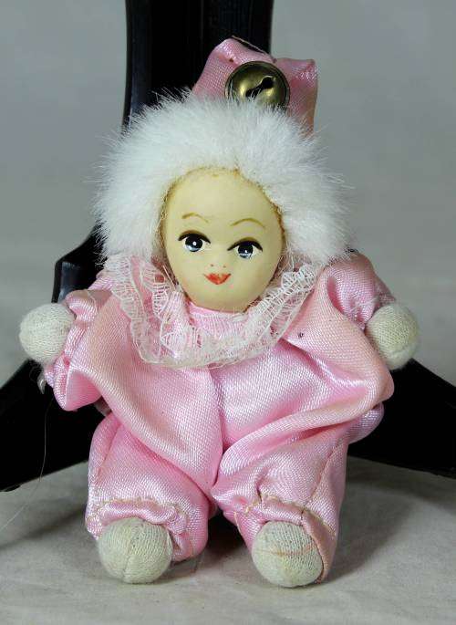porcelain and cloth clown dressed in a pink jump suit