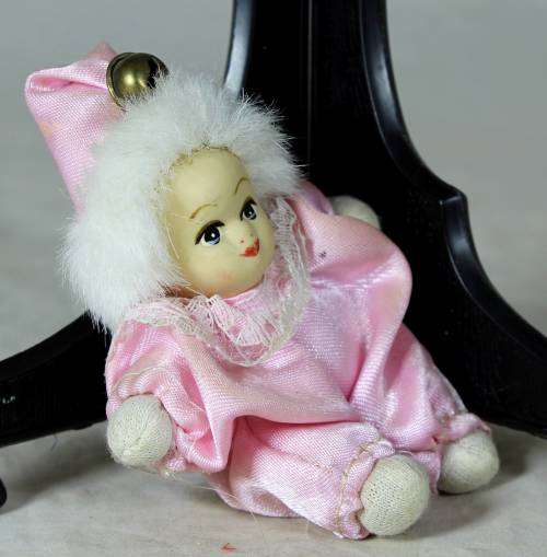 porcelain and cloth clown dressed in a pink jump suit