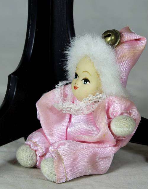 porcelain and cloth clown dressed in a pink jump suit