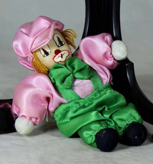 porcelain and cloth clown dressed in green and pink