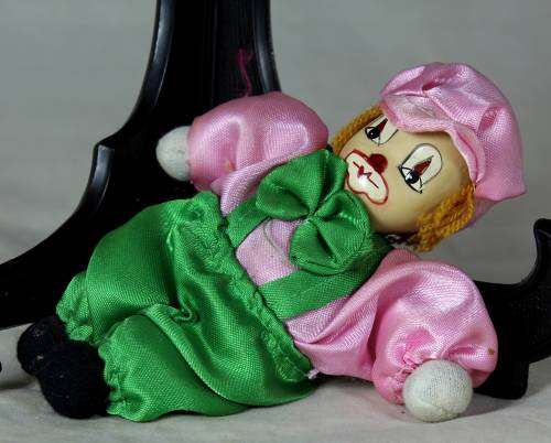 porcelain and cloth clown dressed in green and pink