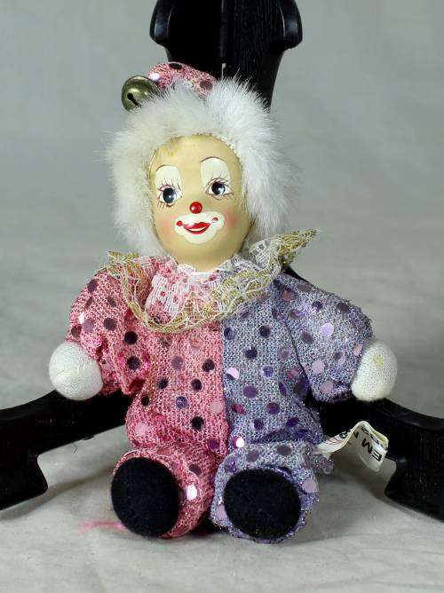 porcelain and cloth clown dressed in a glitter jump suit