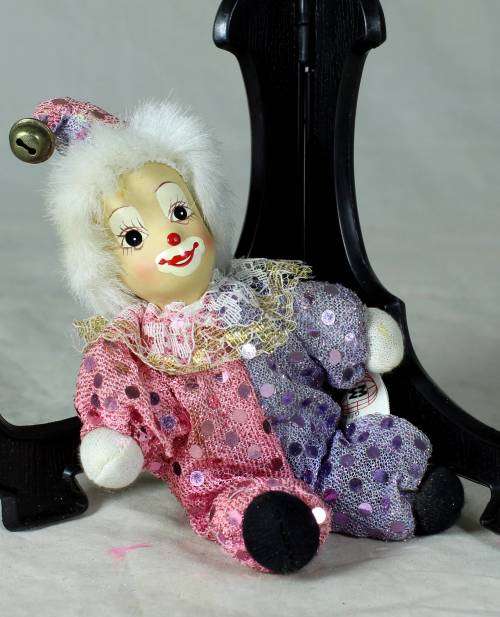 porcelain and cloth clown dressed in a glitter jump suit