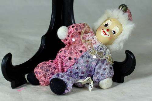 porcelain and cloth clown dressed in a glitter jump suit