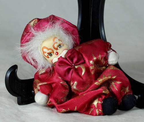 porcelain and cloth clown dressed in a red jump suit