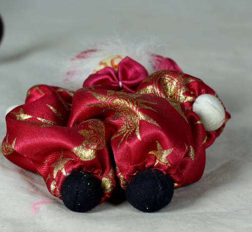 porcelain and cloth clown dressed in a red jump suit